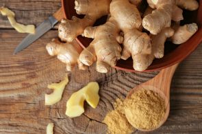 Fresh and ground ginger on wooden table